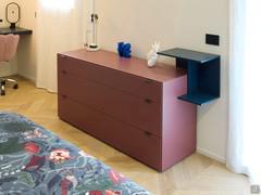 Die Kommode ist farblich auf das ganze Zimmer abgestimmt, in Blau- und Rosatönen.