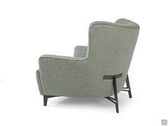 Lateral view of the Doyle armchair, characterised by a welcoming form