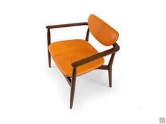 Victoria armchair in Light Brown wood covered in orange leather, a palette the enhancing the retro style of the piece of furniture.