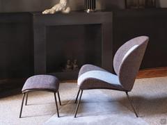 Minimalist armchair with high metal legs, matched with its own coordinated ottoman 