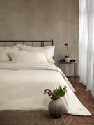 Cream-coloured Percale cotton bedding set consisting of pillowcases with ruffles finished in shadow stitch, duvet cover bag and fitted sheet underneath with corners