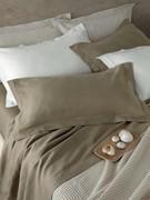 Linen sheets and pillowcases here in a palette of sand tones, with a matching honeycomb cotton bedspread