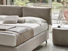 Detail of Ambra bed with two-tone cushions on the headboard