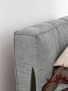 Detail of the upholstered headboard of the bed Fluff by Bonaldo, here offered upholstered in gray fabric