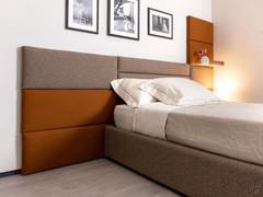 Geco modular upholstered paneling covered in Gyre 9 fabric (gray panels) and Thar 301 (orange panels)