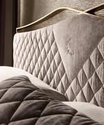 Detail of the velvet quilted headboard with central classy embroidery