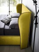 Headboard with side flaps that hint at the lines of a classic armchair