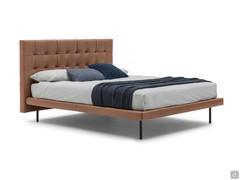 SuperCapitonné bed with low quilted headboard and slim bed frame with high feet