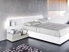 California upholstered bed covered in Lily White faux-leather matched to wall panelling and coordinated bedside tables