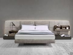 California upholstered bed with wall panelling matched with bedside tables