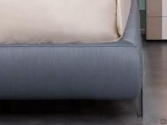 Detail of the stitching and upholstery of the bed frame covered in Hermes 27 Avio fabric