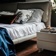 Modern bed with upholstered bed in light coloured leather.