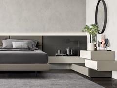 Composition with upholstered bed frame and central headboard, complemented by lacquered panels and hanging elements