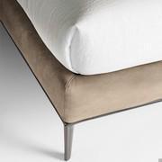 The delicate contrast between the upholstered bed frame and the metal base with legs