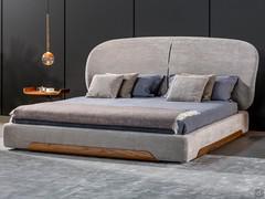 Olos bed with a large, elliptical-shaped enveloping headboard with a height of 120 cm.