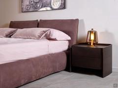 Astoria bed upholstered in Nabuk leather, combined with Amandla wooden bedside table