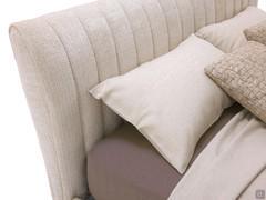 Detail of the headboard upholstery in Aurora fabric, a soft chenille that enhances the full and important shapes