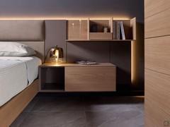 Matt lacquered California boiserie complemented by suspended wooden storage units and a chest of drawers with open compartment for use as a bedside table