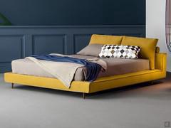 Owen bed with quilted upholstery, shaped painted metal feet