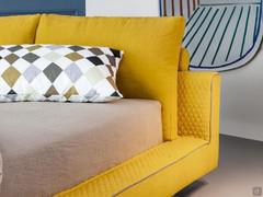 Delicate quilting on bed frame and headboard with cylindrical cushions