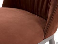 Detail of the curved upholstered backrest with folds on the inside 