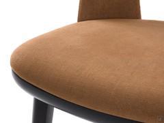 Detail of seat with lower wooden shell matching the 4 legs and upholstered panel covered in fabric