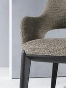 Detail of the Turner upholstered chair with legs and structure below the seat made from oak wood 