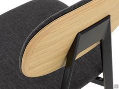 Detail of the upholstered backrest covered in fabric with wooden rear part