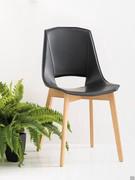 Chair Nicole in the version with black regenerated leather seat and natural oak legs