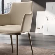 Close up of the Michela upholstered armchair. Leather upholstery and metal legs in the Bronze finish.