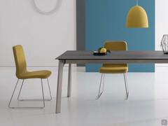 Kate upholstered chair with metal sled legs, coverd in yellow and ideal for the dining area