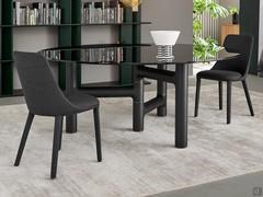 Upholstered chairs Itala by Bonaldo coordinate the dark tones of the Pivot table, also by Bonaldo