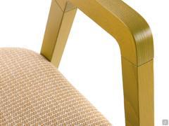 Close-up of the ash wood armrest of the Bryanna chair with the stained finish in the colour Curry Yellow