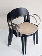 Detail of the Minima chair in Coal stained ash with Vienna straw seat and flat metal armrests in burnished brass finish