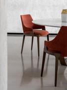 Detail of Velis chair with upholstered body and solid wood frame