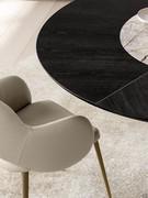 Camille upholstered lounge chair with stitching that emphasises its curved lines