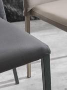 Detail of connection between painted metal leg and seat covered in leatherette with matching stitching