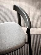 Detail of the slim, minimal backrest made of curved solid wood