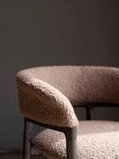 Detail of the curved backrest with solid wood lower profile and upholstered, fabric-covered backrest