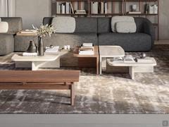 Coffee tables Auri in travertine marble and canaletto walnut combined with the elegant curved sofa Laurent