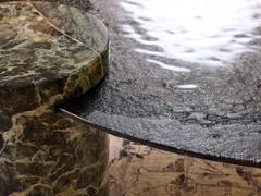 Detail of the combination of hammered glass top and Verde Alpi marble cylinder, two features that make the Piece coffee table instantly recognisable