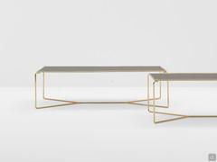 Particularity of the Proust coffee tables with fumé glass tops, framed by the tubular Brass metal structure