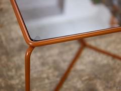 Close-up of the tubular metal structure which delicately frames the top in fumé glass