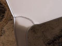 Detail of the connection between the top and legs of the coffee table Elgon fully covered in leather