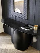 View from above of the Torquay console table with a wrap-around metal base painted in black, and a top in glossy black hammered glass