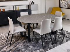 Extendable round dining table Lawrence in the version with laminated HPL top and black painted metal base