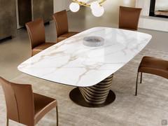 Table Vortex in the 240 x 120 cm barrel format with a polished calacatta old stain ceramic top and vintage brushed bronze metal designer tortile base