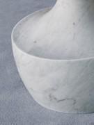 Detail of the sculptural plinth in matte White Carrara marble