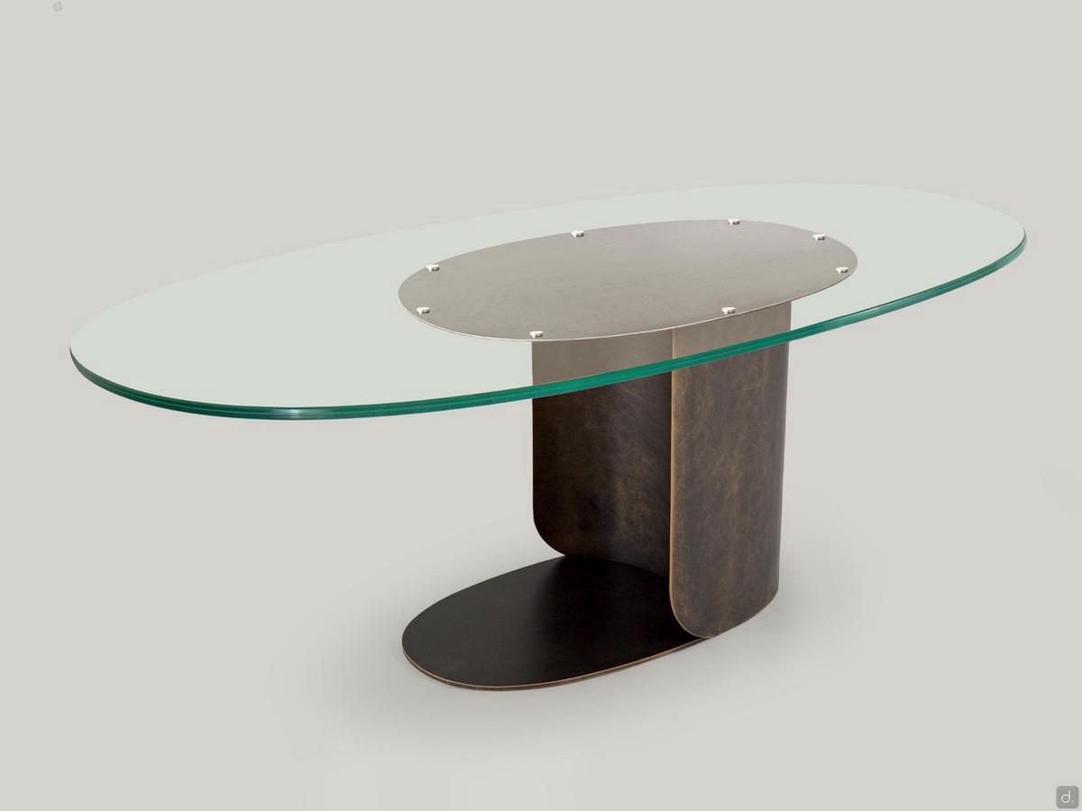 Phantom industrial design table in glass and metal, with elliptic top and bent metal sheet base.