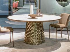 The table is characterized by the design of the base, consisting of two curved mirrored crystal "shells"